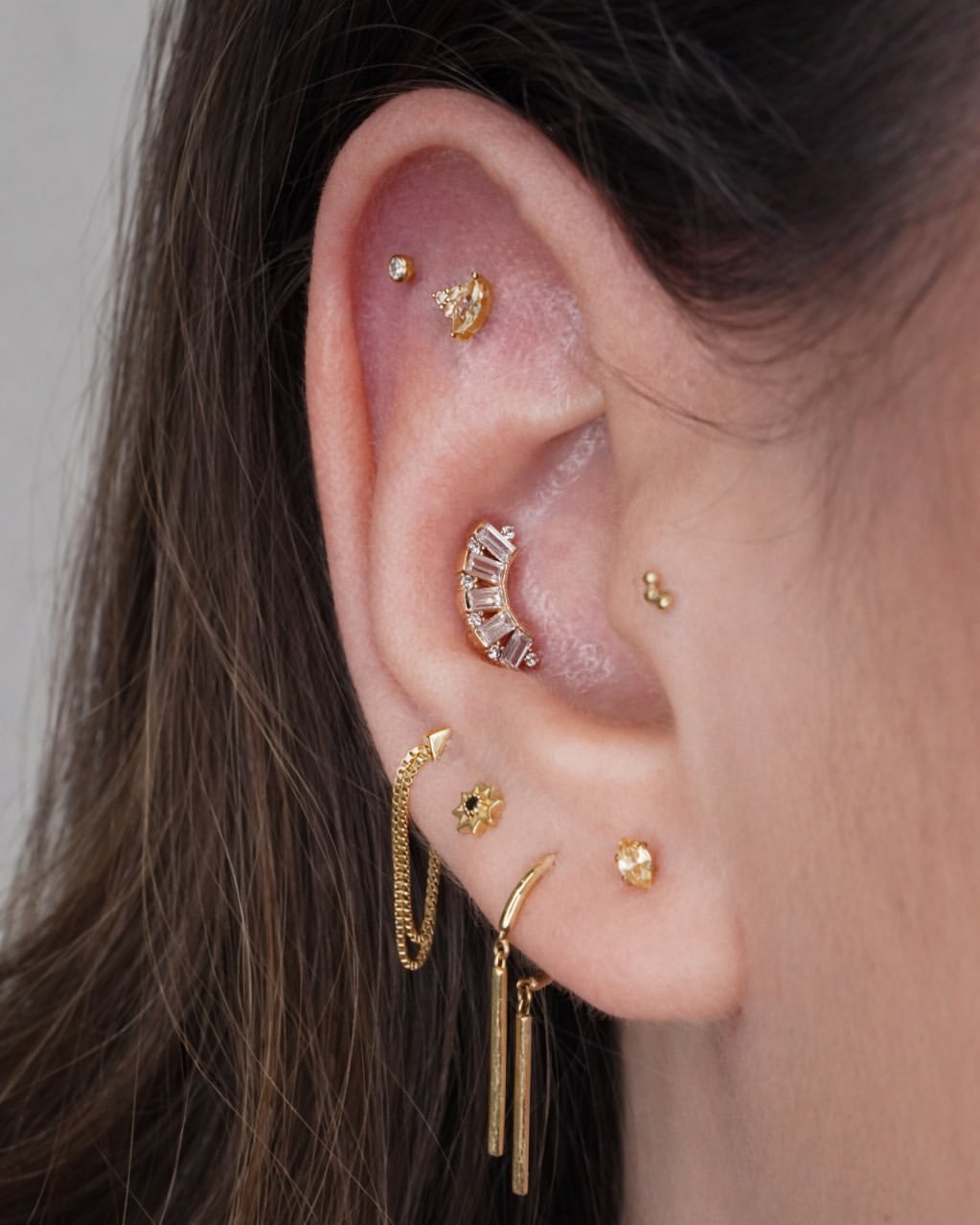 Flat piercing with gold jewelry in Barcelona - Circa Piercing