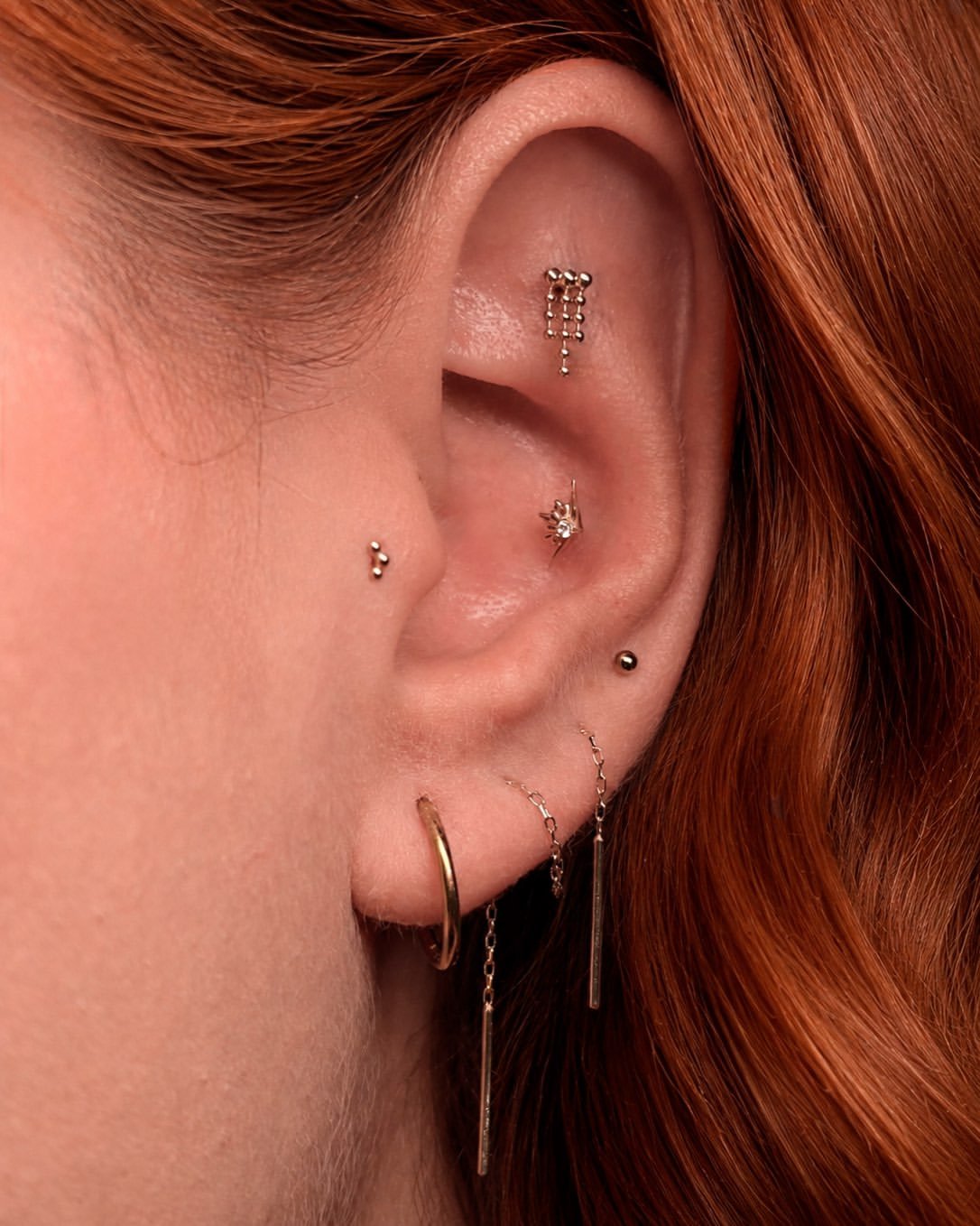 Tragus piercing with gold jewelry in Barcelona - Circa Piercing